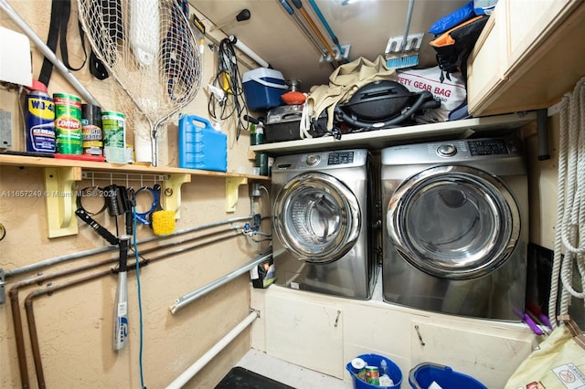 washroom featuring washing machine and clothes dryer and cabinets