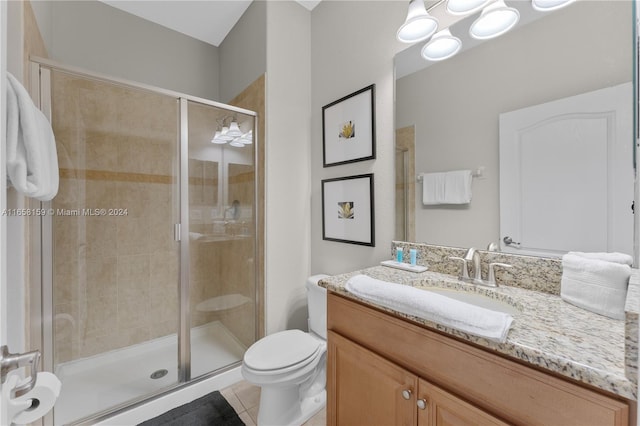 bathroom with vanity, toilet, tile patterned floors, and a shower with shower door