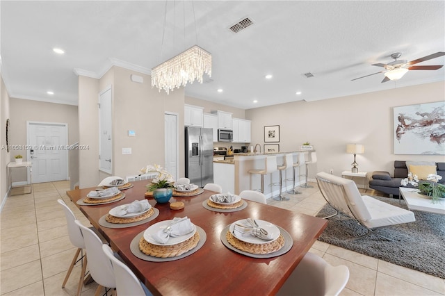 tiled dining area featuring ornamental molding and ceiling fan