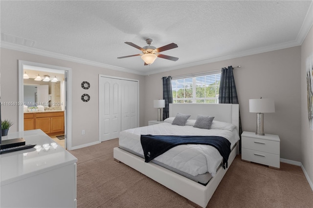 bedroom featuring ornamental molding, ceiling fan, a closet, ensuite bathroom, and light colored carpet