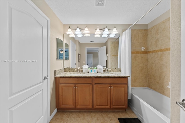 bathroom featuring a textured ceiling, vanity, tile patterned floors, and shower / bathtub combination with curtain