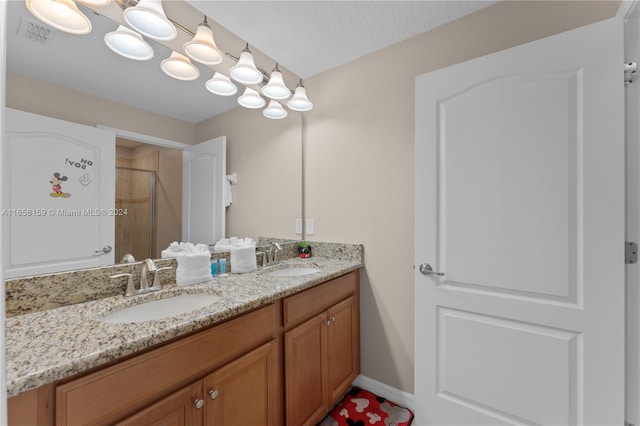 bathroom with tiled shower, vanity, and a textured ceiling