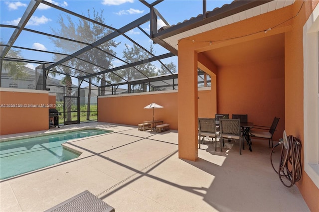 view of pool featuring glass enclosure and a patio