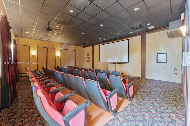 carpeted cinema room featuring a paneled ceiling