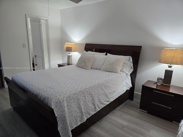 bedroom featuring light wood-type flooring and a textured ceiling