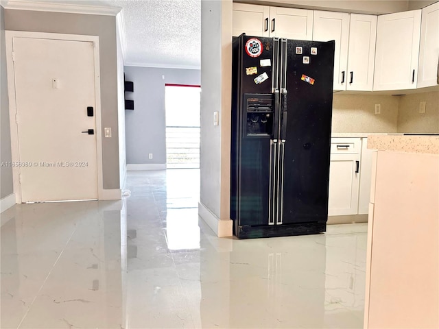 kitchen with black fridge, ornamental molding, white cabinetry, and a textured ceiling