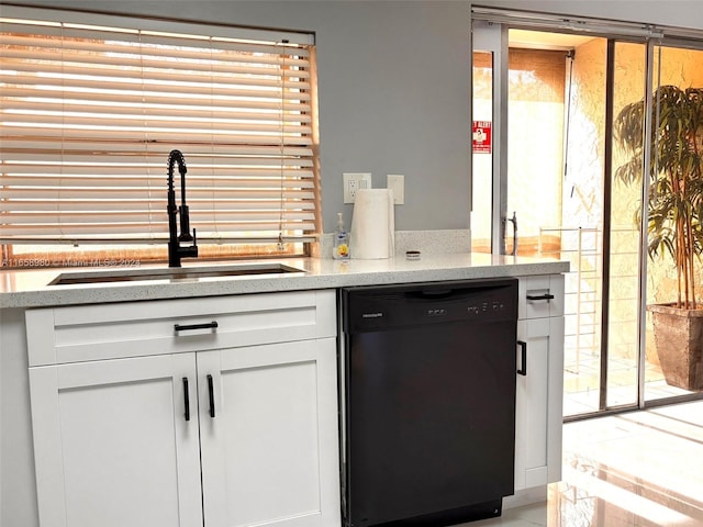 kitchen featuring black dishwasher, sink, and white cabinets