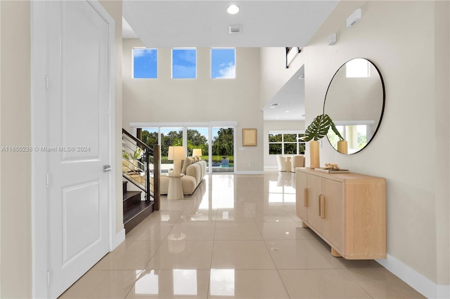 corridor featuring a high ceiling and light tile patterned floors