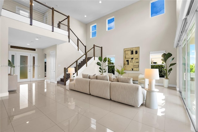 tiled living room with french doors and a high ceiling