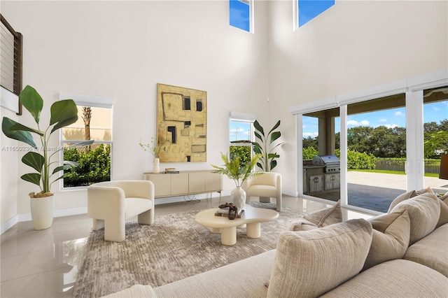 interior space with a towering ceiling, light tile patterned flooring, and a healthy amount of sunlight