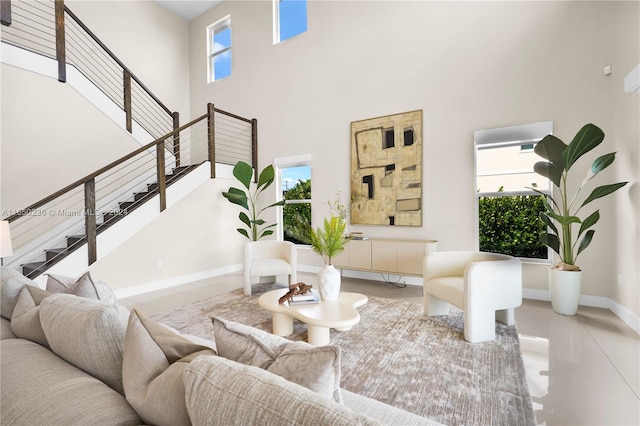 living room with a healthy amount of sunlight, a towering ceiling, and light tile patterned floors