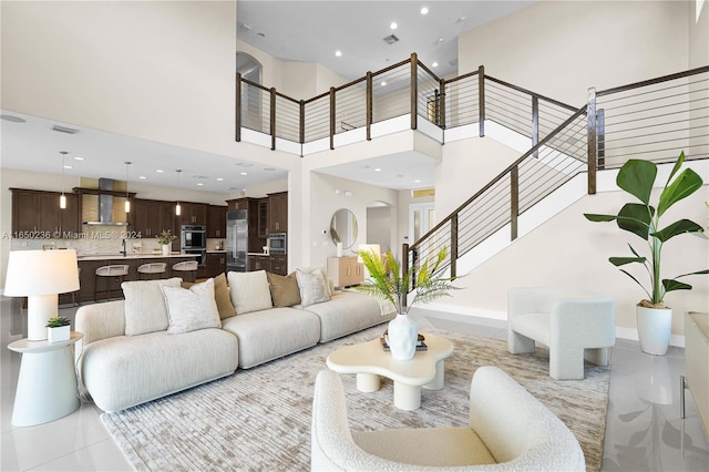 tiled living room featuring sink and a high ceiling