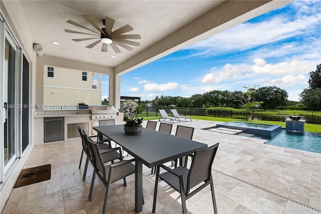 view of patio featuring area for grilling, ceiling fan, an outdoor kitchen, and a swimming pool with hot tub