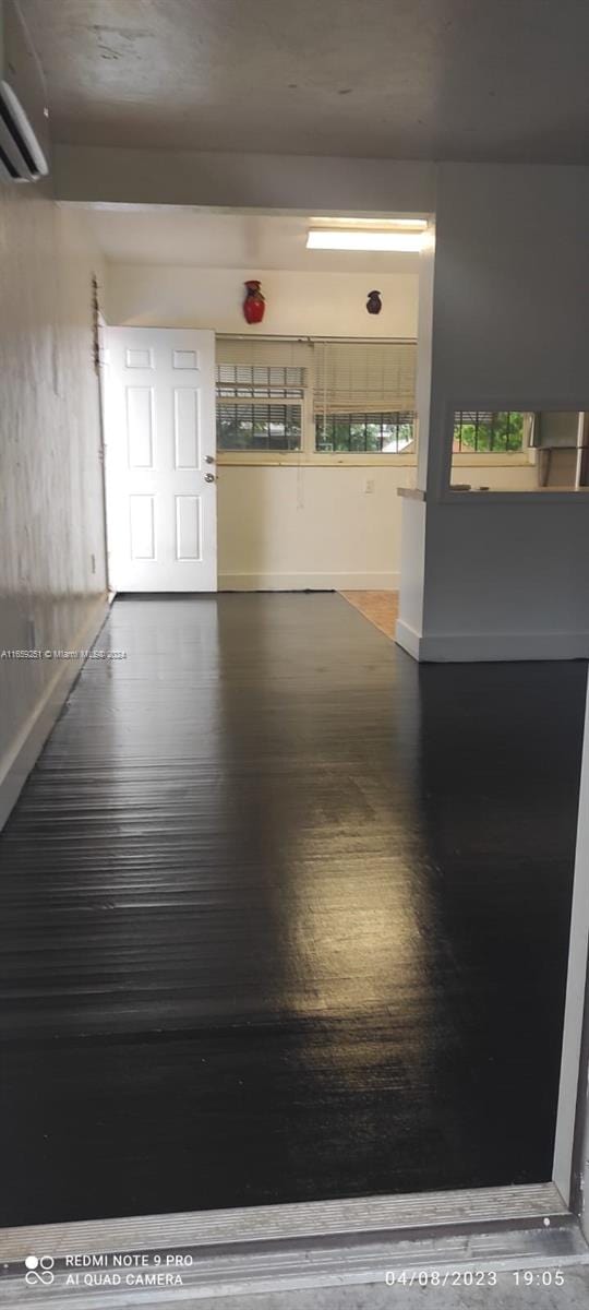 interior space featuring a wall mounted AC and wood-type flooring