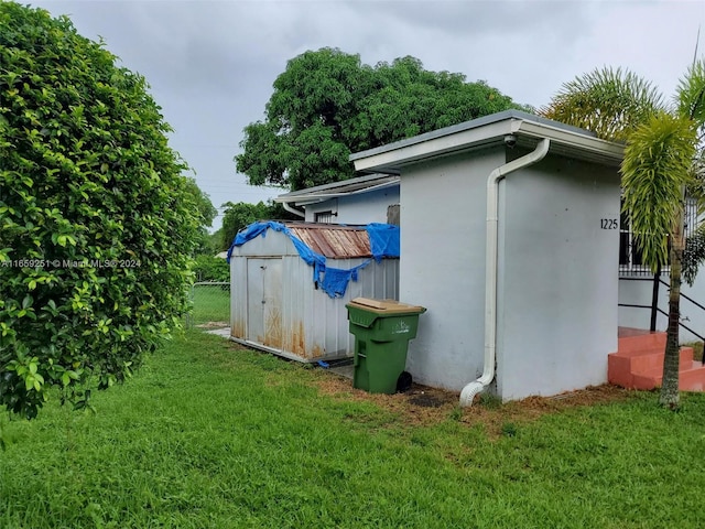 view of side of property featuring a yard and a storage unit