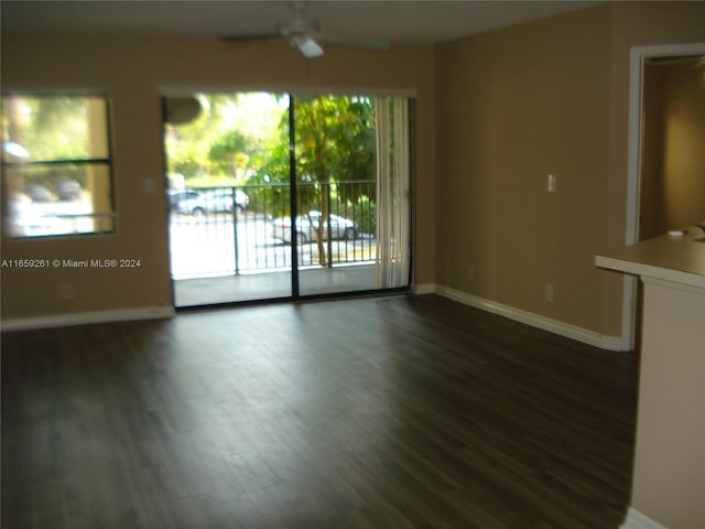 empty room with dark wood-type flooring and ceiling fan