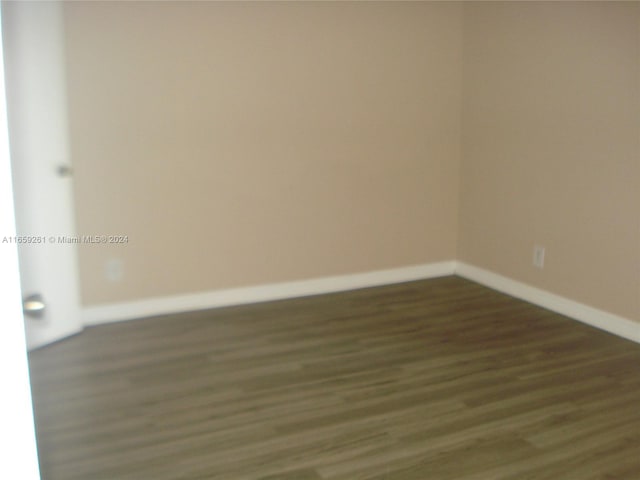 empty room with dark hardwood / wood-style flooring