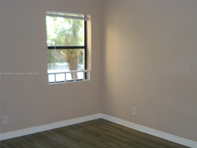 unfurnished room with dark hardwood / wood-style flooring