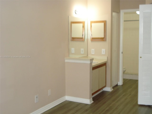 bathroom featuring wood-type flooring, toilet, and vanity