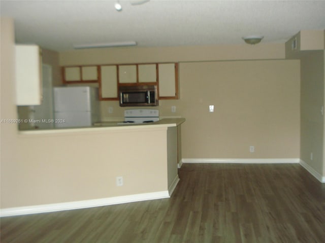 kitchen with dark wood-type flooring, range, and white fridge