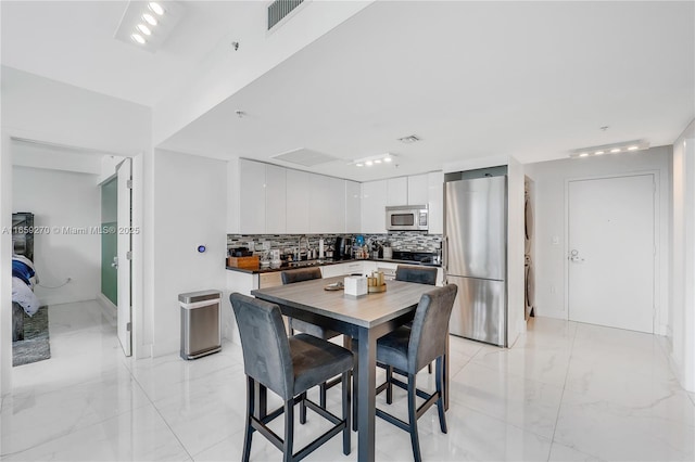 dining space featuring visible vents and marble finish floor