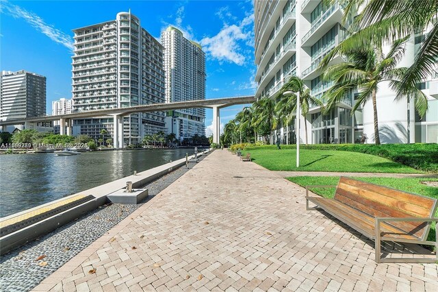 view of property's community featuring a lawn and a water view