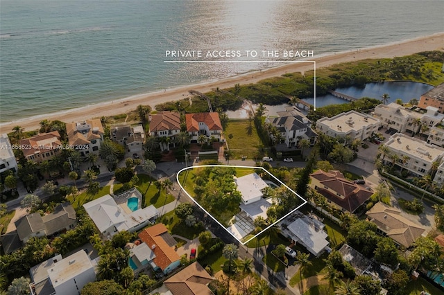 birds eye view of property with a water view and a view of the beach