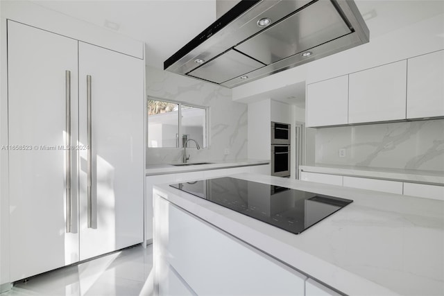 kitchen featuring sink, paneled built in fridge, black electric stovetop, white cabinets, and exhaust hood