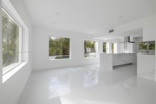 spare room with marble finish floor, visible vents, and baseboards