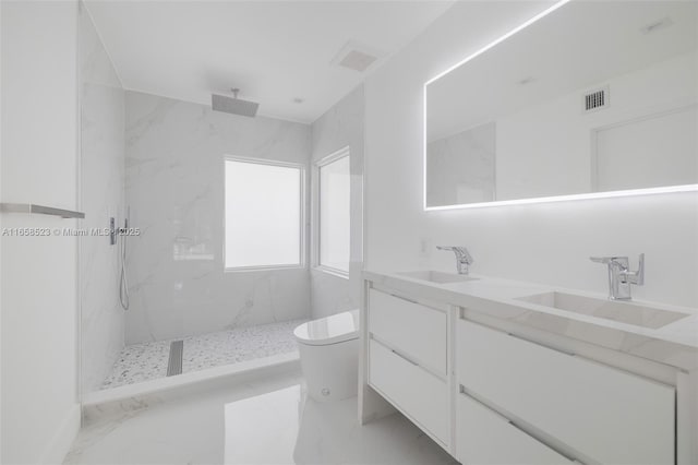 full bath featuring toilet, a marble finish shower, double vanity, and a sink