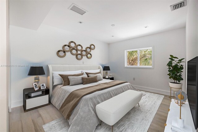 bedroom featuring light wood-style floors, baseboards, and visible vents