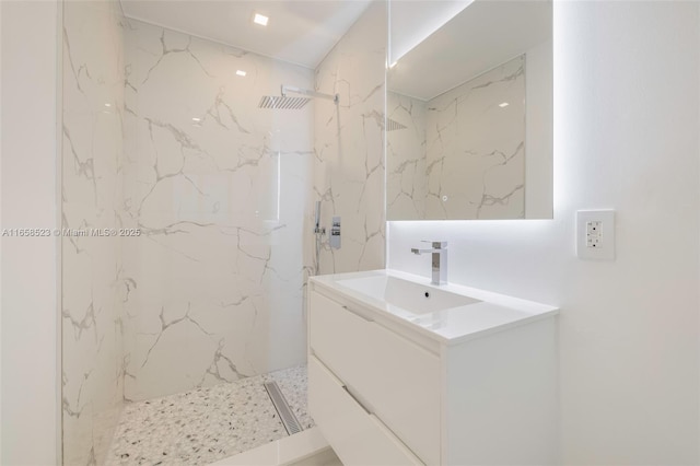 bathroom with visible vents, vanity, and a marble finish shower