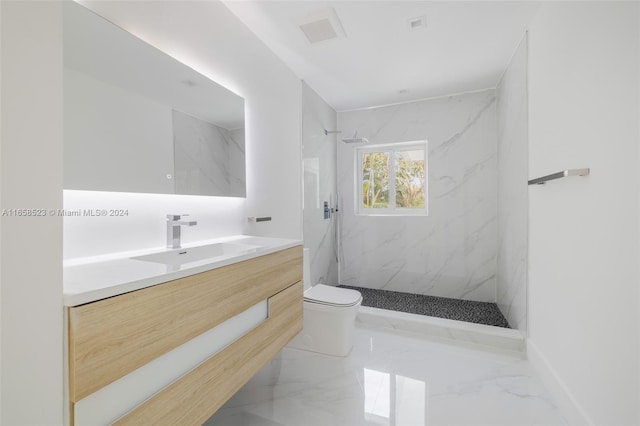 bathroom with tiled shower, vanity, and toilet