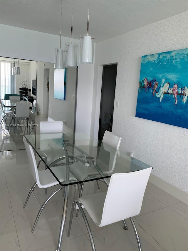 3801 S Ocean Dr Unit 12M, Hollywood, FL 33019 - dining room featuring a textured wall, light marble finish floors, and baseboards