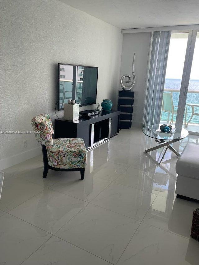 3801 S Ocean Dr Unit 12M, Hollywood, FL 33019 - living area with a textured wall, marble finish floors, and baseboards