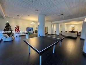 game room featuring dark hardwood / wood-style floors and an inviting chandelier