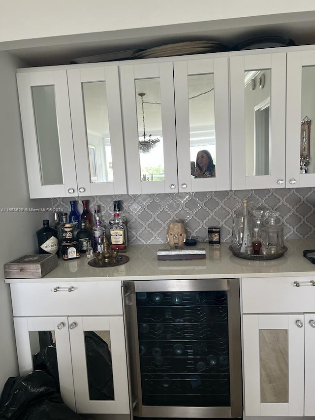 kitchen with beverage cooler, white cabinetry, and tasteful backsplash