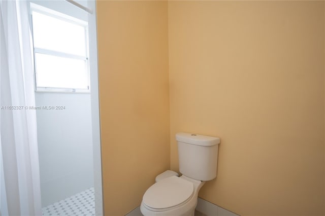 bathroom with walk in shower and toilet