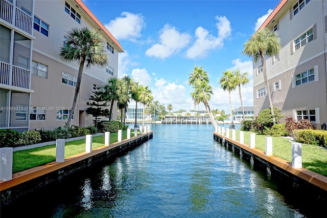 view of dock with a water view and a lawn