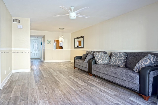 living room featuring wood-type flooring and ceiling fan