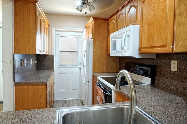 kitchen with ceiling fan, sink, white appliances, and decorative backsplash