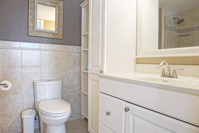 bathroom featuring vanity, tile walls, tile patterned floors, and toilet