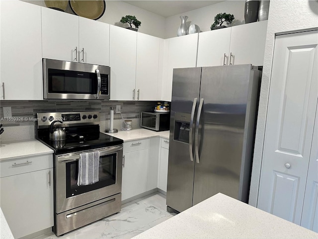 kitchen with appliances with stainless steel finishes, backsplash, and white cabinetry