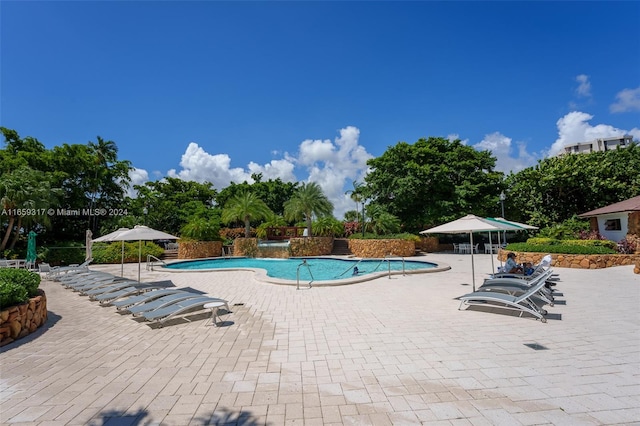 view of pool featuring pool water feature and a patio