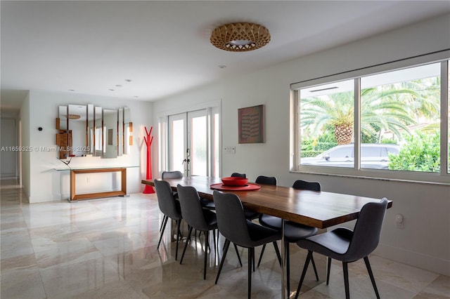 dining space with marble finish floor, french doors, and baseboards