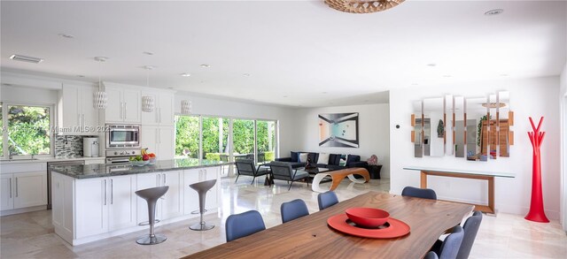 dining area featuring sink, a healthy amount of sunlight, and light tile patterned floors