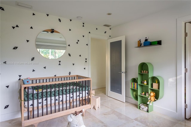 bedroom featuring a crib, visible vents, and baseboards