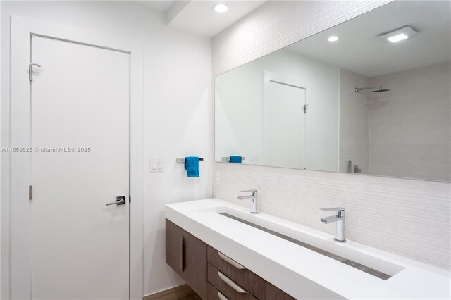 bathroom with vanity, tasteful backsplash, and a shower