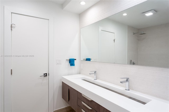 bathroom with backsplash, vanity, and recessed lighting