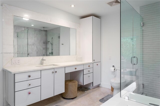 bathroom with vanity, toilet, a shower with shower door, and tile patterned flooring